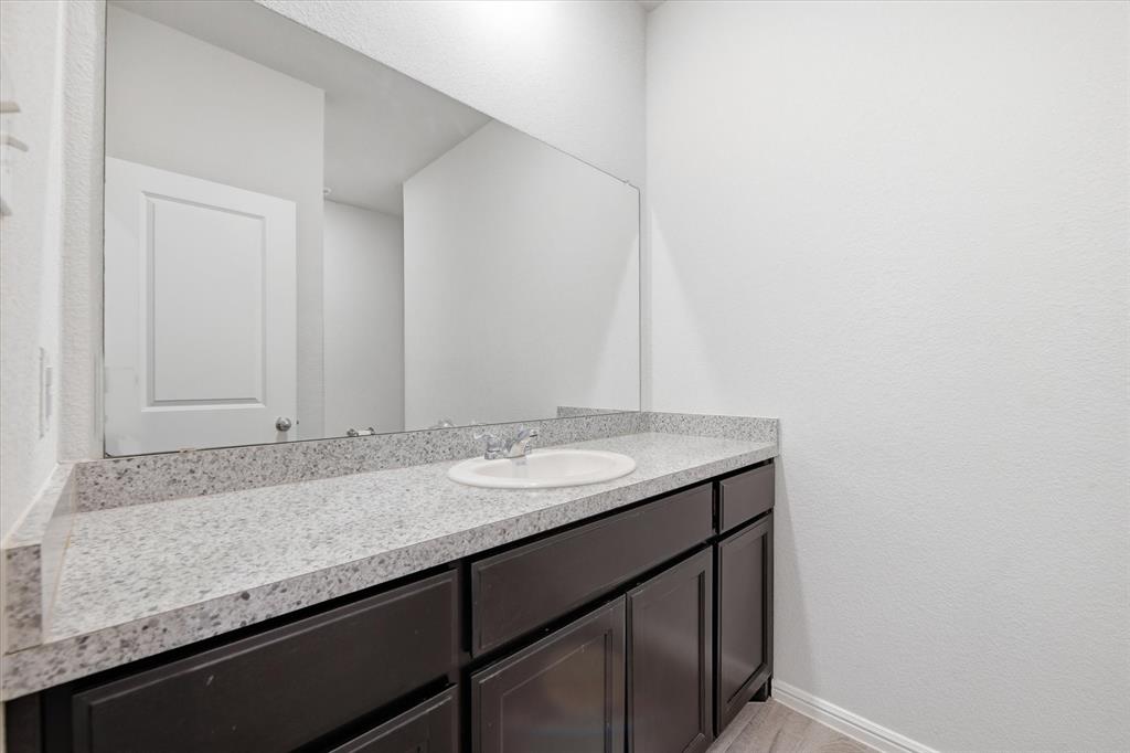9308 Desertrock Road Fort Worth, TX 76131 - Photo 15 of 23 a bathroom with a granite countertop sink and a mirror