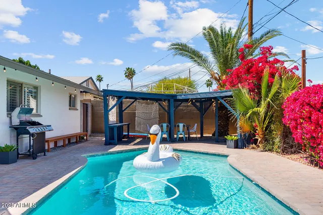 a front view of a house with swimming pool and sitting area