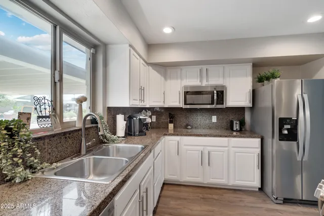 a kitchen with stainless steel appliances granite countertop a sink stove and refrigerator