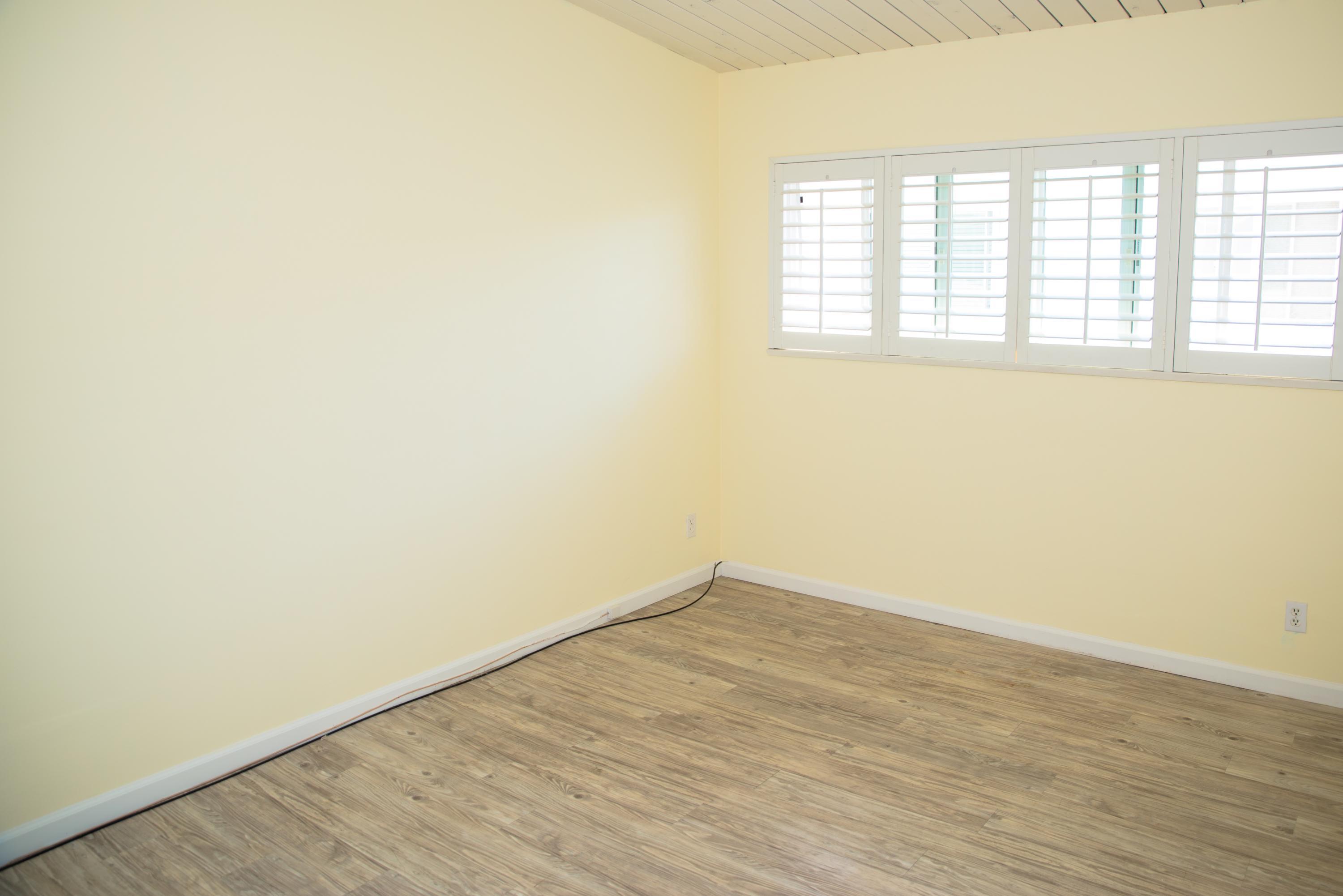 4950 Sandyland Road, Unit 220 Carpinteria, CA 93013 - Photo 13 of 20 an empty room with wooden floor and windows