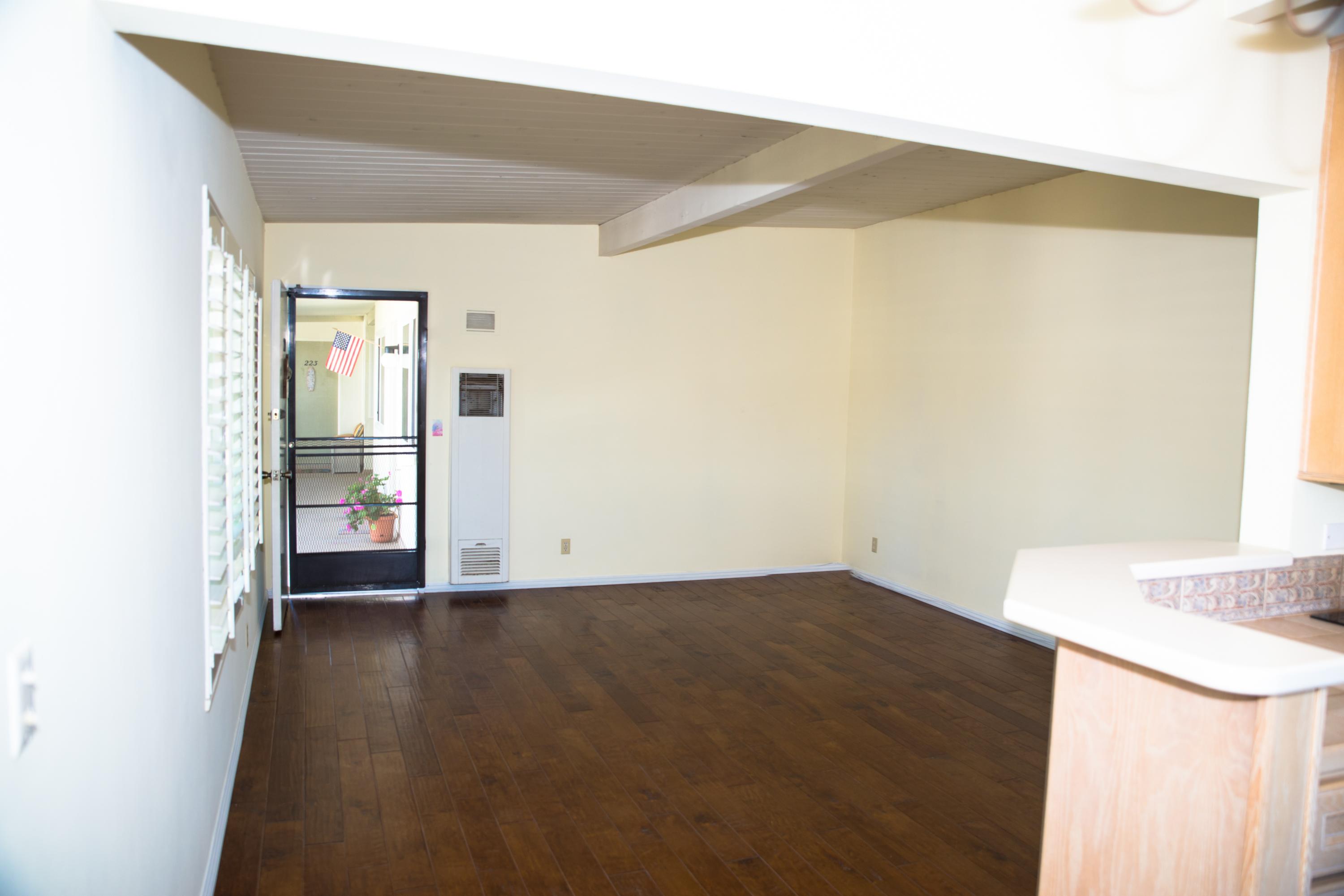 4950 Sandyland Road, Unit 220 Carpinteria, CA 93013 - Photo 7 of 20 an empty room with wooden floor and windows