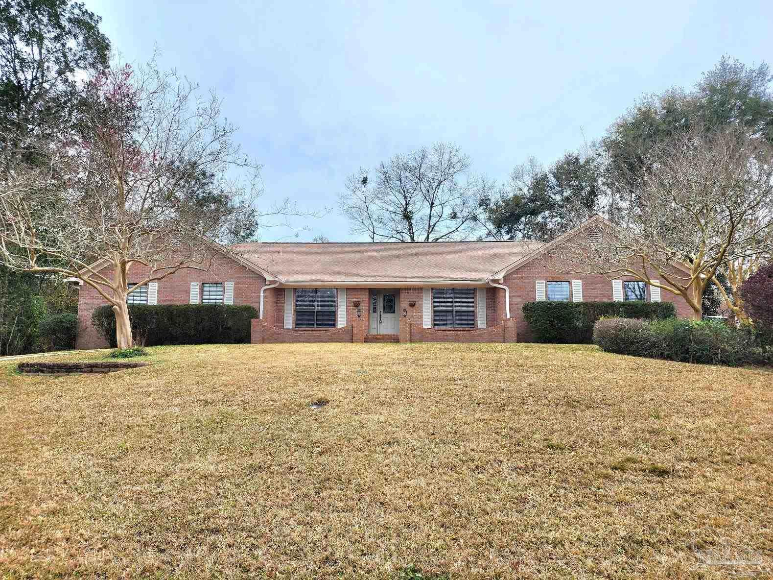 9001 Woodrun Road Pensacola, FL 32514 - Photo 1 of 24 a front view of a house with a yard