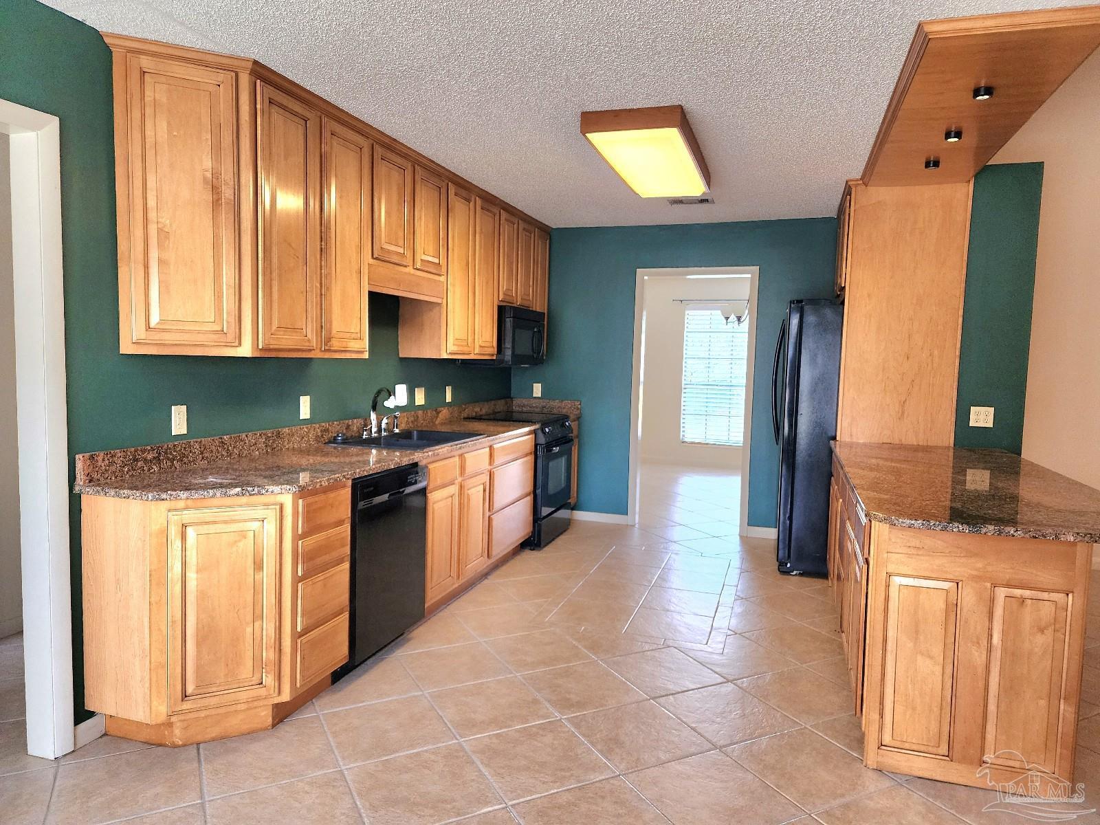 9001 Woodrun Road Pensacola, FL 32514 - Photo 4 of 24 a kitchen with stainless steel appliances granite countertop a stove a sink and a microwave