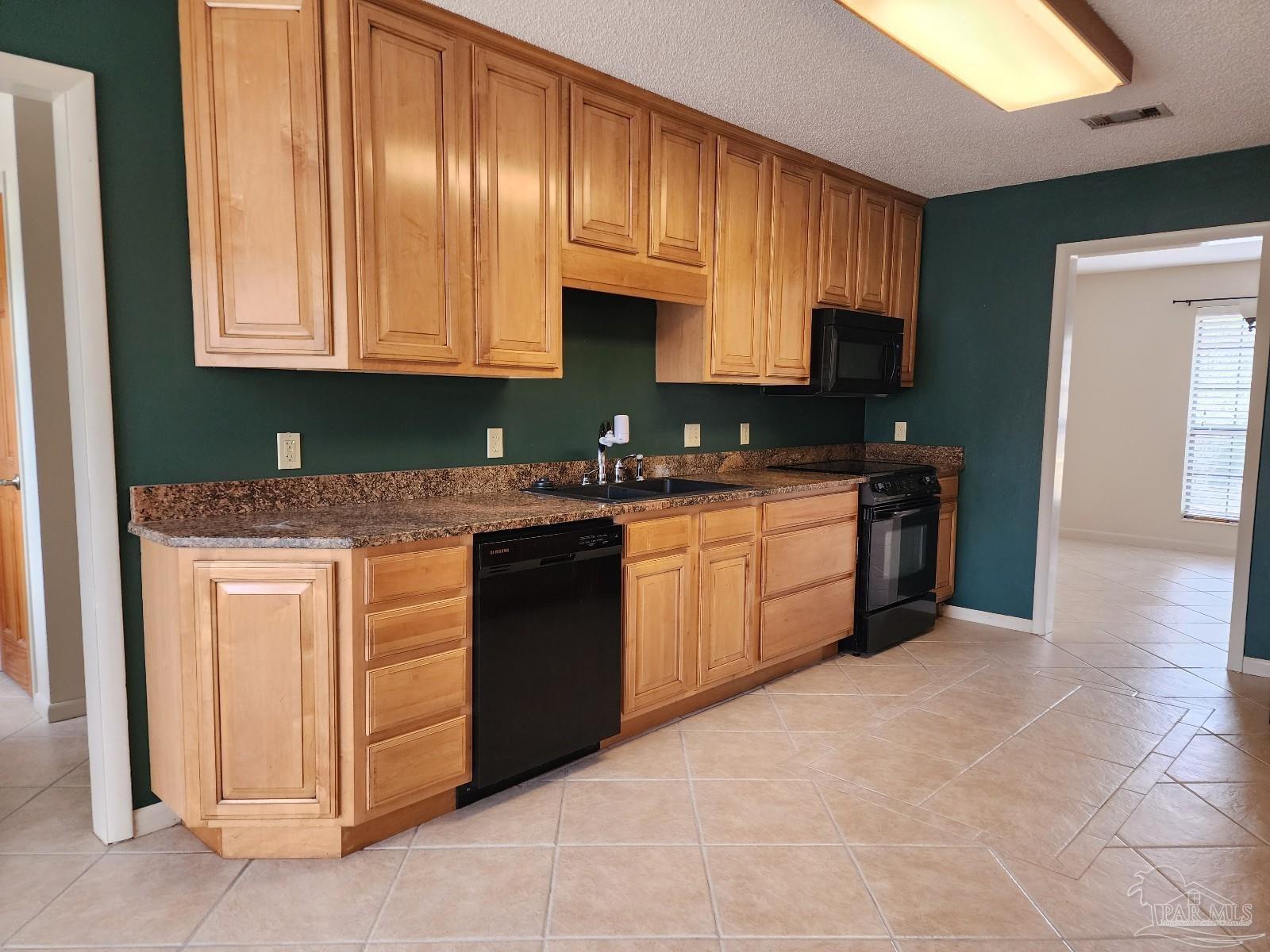 9001 Woodrun Road Pensacola, FL 32514 - Photo 5 of 24 a kitchen with stainless steel appliances granite countertop a stove sink and cabinets