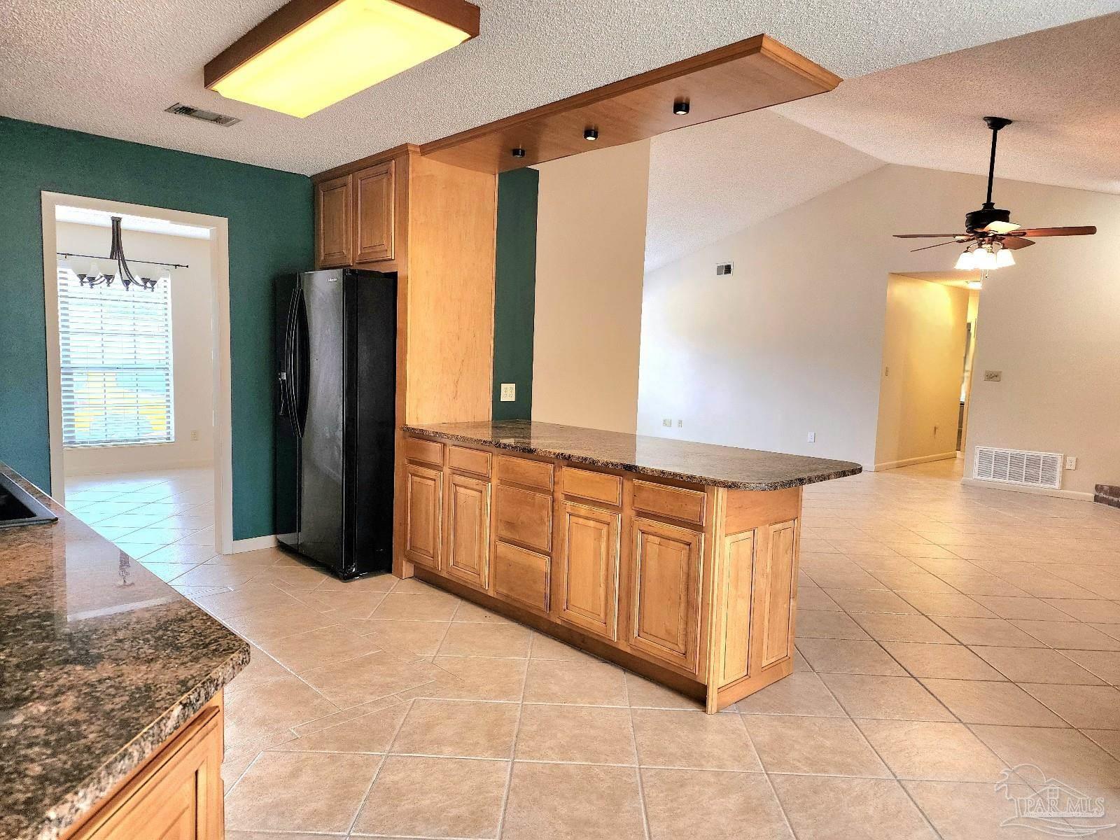 9001 Woodrun Road Pensacola, FL 32514 - Photo 6 of 24 a kitchen with stainless steel appliances granite countertop a sink and a refrigerator