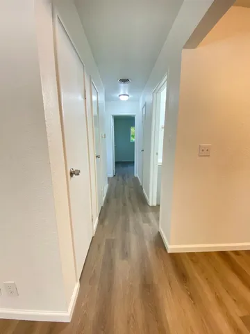 a view of a hallway with wooden floor