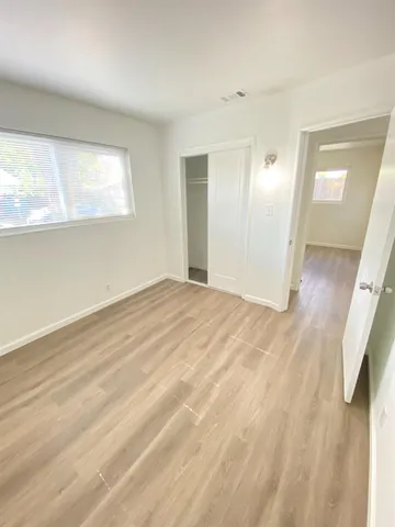 a view of empty room with wooden floor
