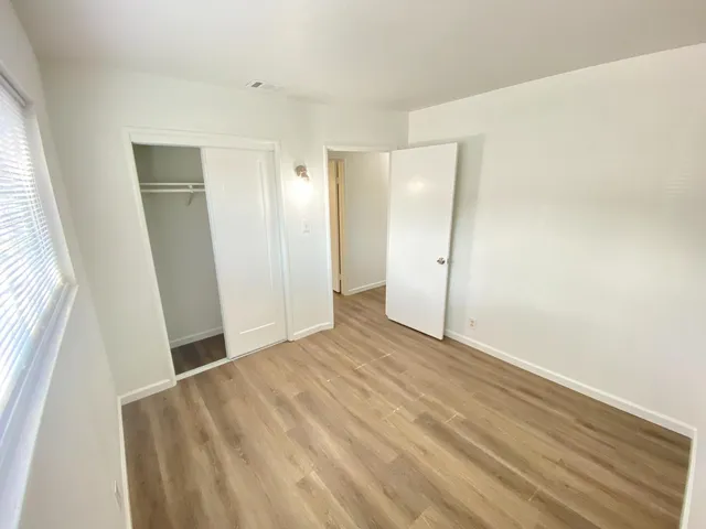 a view of an empty room with wooden floor