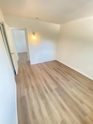 a view of a big room with wooden floor and windows