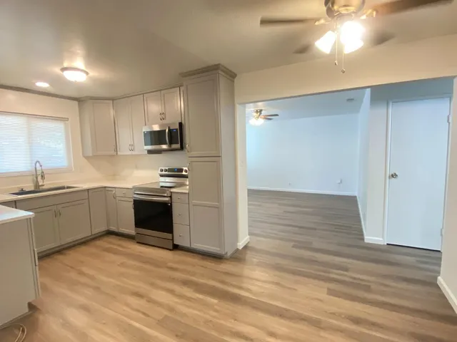a kitchen with granite countertop a refrigerator and a stove top oven