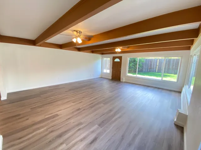 wooden floor in an empty room with a window