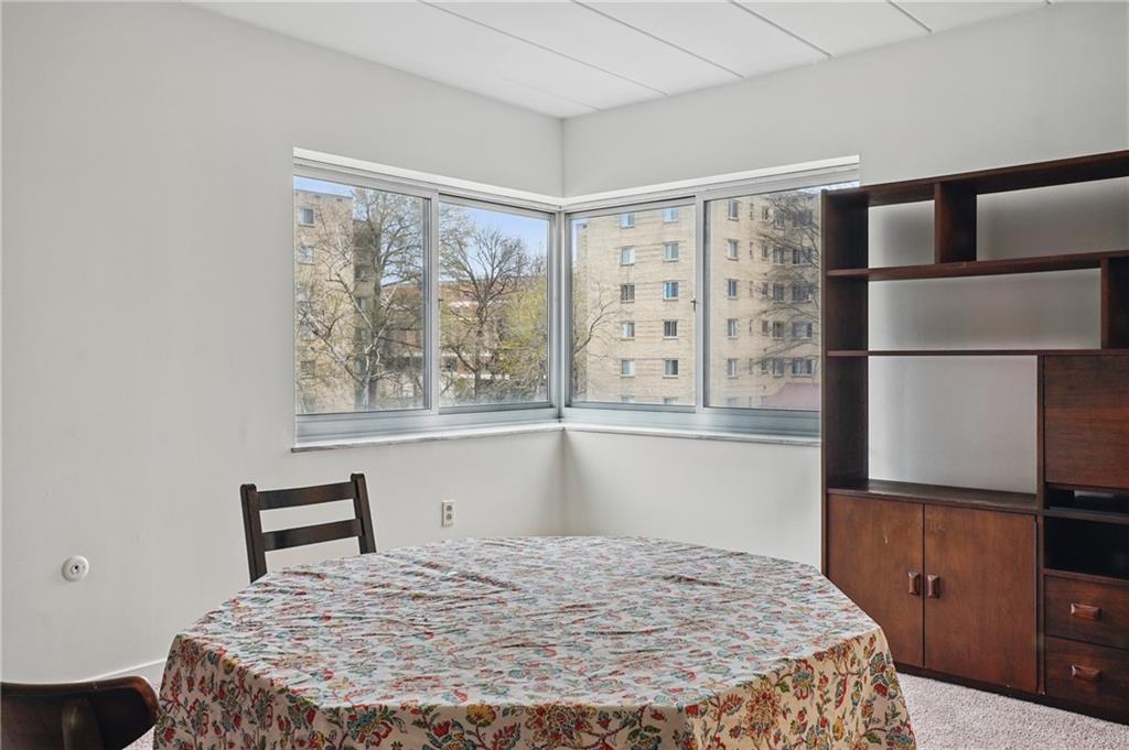5 Bayard Road, Unit 400 Pittsburgh, PA 15213 - Photo 15 of 33 A dining area with big windows and neutral carpets offers a bright and airy atmosphere, perfect for both everyday meals and special gatherings.
