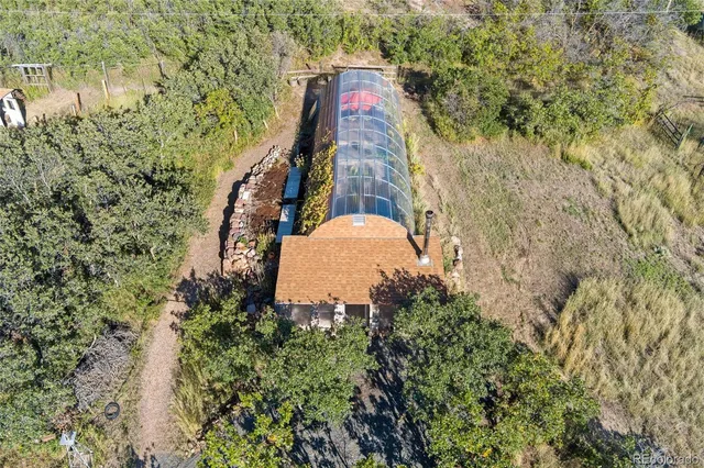 an aerial view of a house with a garden and large trees