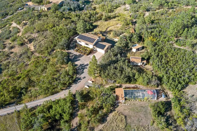 an aerial view of residential houses with outdoor space and trees