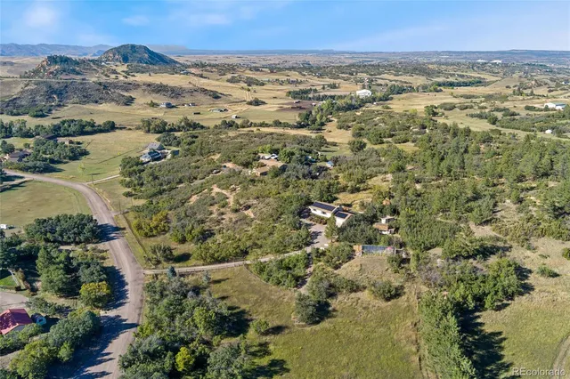 an aerial view of mountains residential house and green space