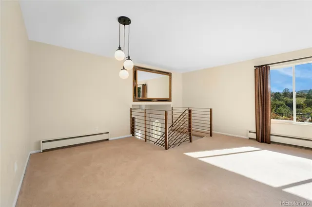 a view of an empty room with window and cabinet