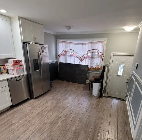 a room with wooden floors and appliances
