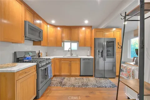 a kitchen with a refrigerator a sink and a stove top oven