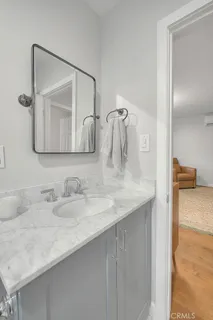 a bathroom with a granite countertop sink and a mirror