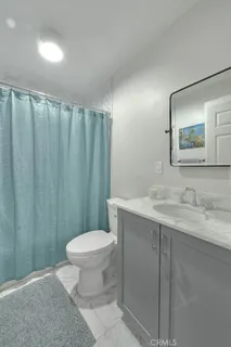 a bathroom with a granite countertop sink toilet and a mirror