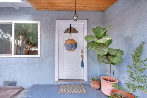 a vase of flowers sitting on a table with a potted plant