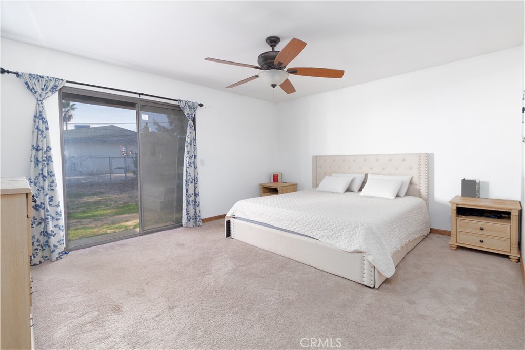 19801 Talihina Road Apple Valley, CA 92307 - Photo 15 of 32 a spacious bedroom with a bed and a large window