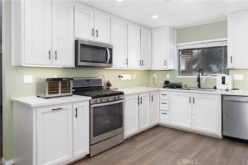 19801 Talihina Road Apple Valley, CA 92307 - Photo 8 of 32 a kitchen with cabinets stainless steel appliances a sink and a window