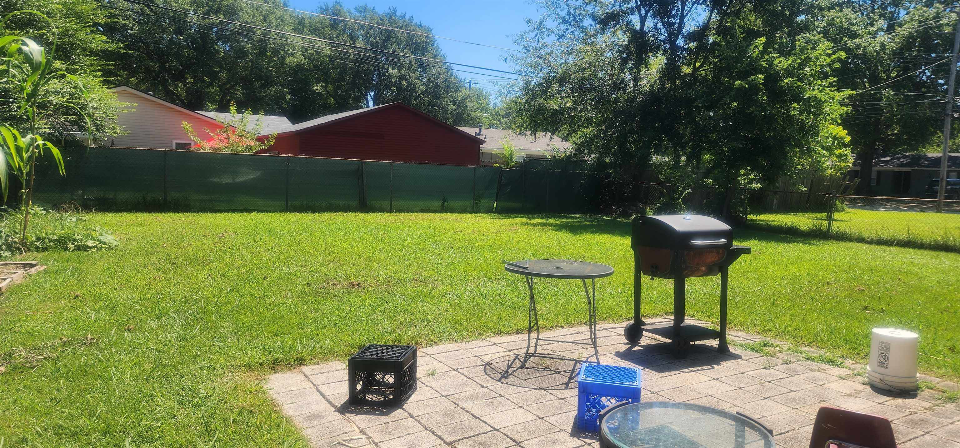 1804 Capri Road Memphis, TN 38117 - Photo 3 of 3 a backyard of a house with table and chairs