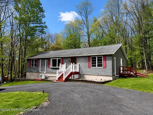 a view of house with backyard space and trees