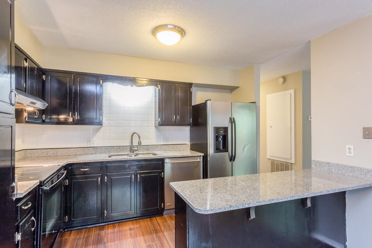 5036 Flint Ridge Place, Unit 5036 Raleigh, NC 27609 - Photo 6 of 18 a kitchen with stainless steel appliances granite countertop a sink stove and refrigerator