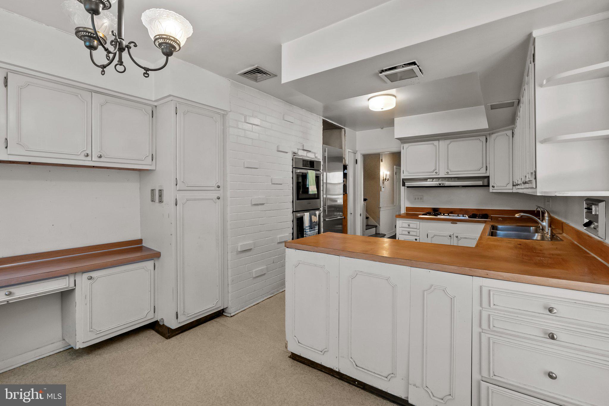 326 Hidden River Road Penn Valley, PA 19072 - Photo 19 of 56 a kitchen with stainless steel appliances granite countertop a refrigerator a sink dishwasher and white cabinets with wooden floor