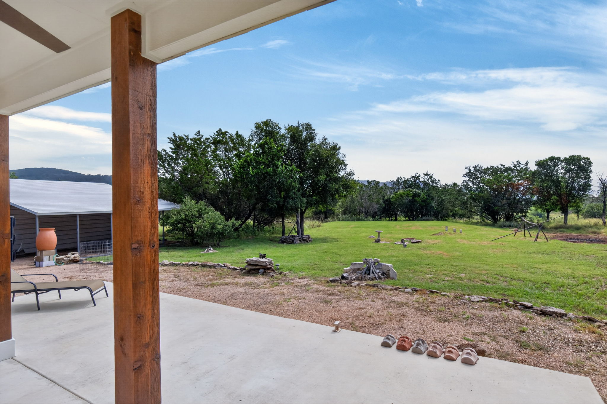 207 Deer Ridge Drive Burnet, TX 78611 - Photo 10 of 36 A spacious concrete patio opens to a sprawling yard, offering ample outdoor enjoyment and view of native wildlife