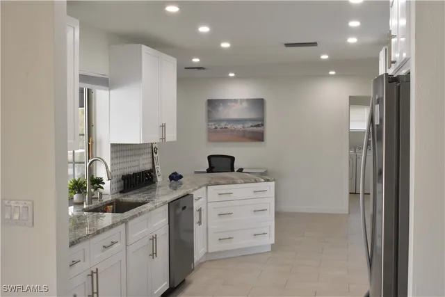 a kitchen with white cabinets and appliances