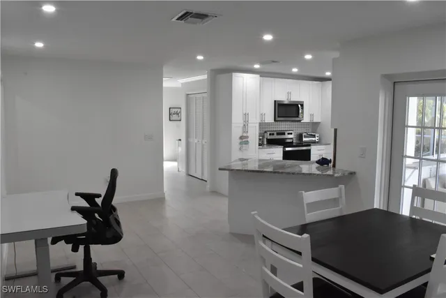 a kitchen with stainless steel appliances kitchen island sink refrigerator and microwave