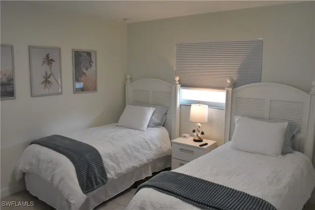 a bedroom with two beds and painting on the wall