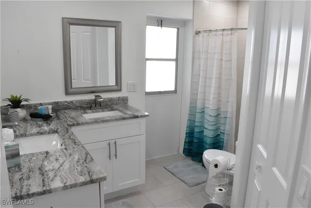 a bathroom with a granite countertop sink a toilet and a mirror