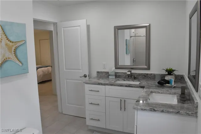 a bathroom with a granite countertop sink and a mirror