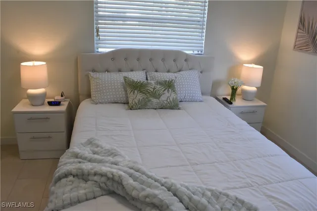 a large bed sitting in a bedroom next to a lamp