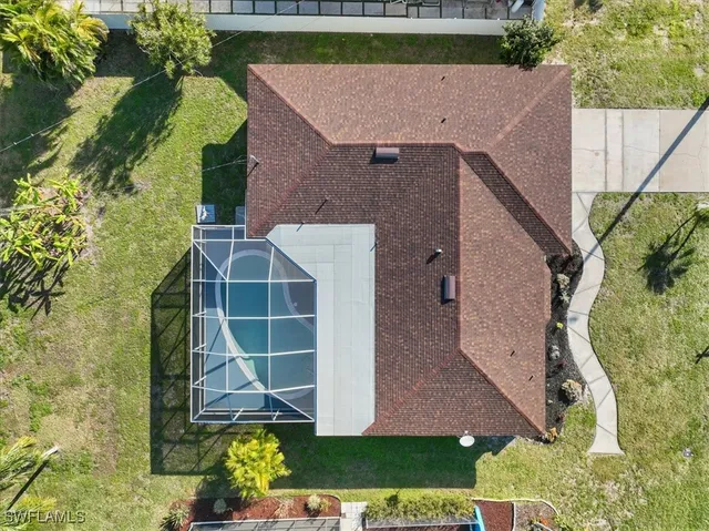 an aerial view of a house with a yard and large trees
