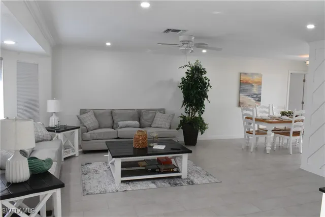 a living room with furniture plant and a chandelier