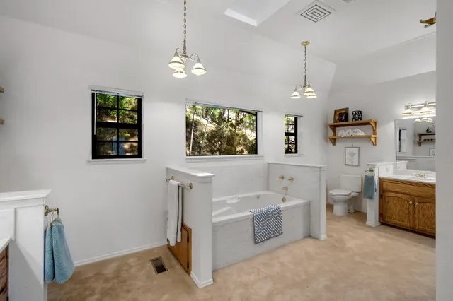 a living room with furniture a chandelier and a window