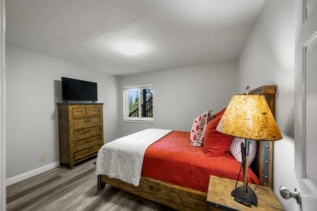 a bedroom with a bed a lamp and a flat screen tv