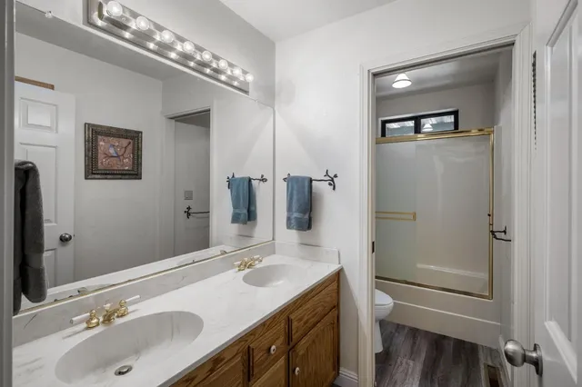 a bathroom with a sink double vanity granite tub and shower