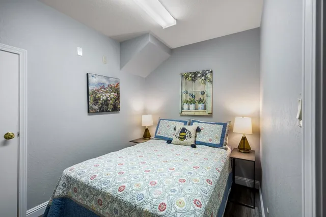 a bedroom with a bed and painting on the wall