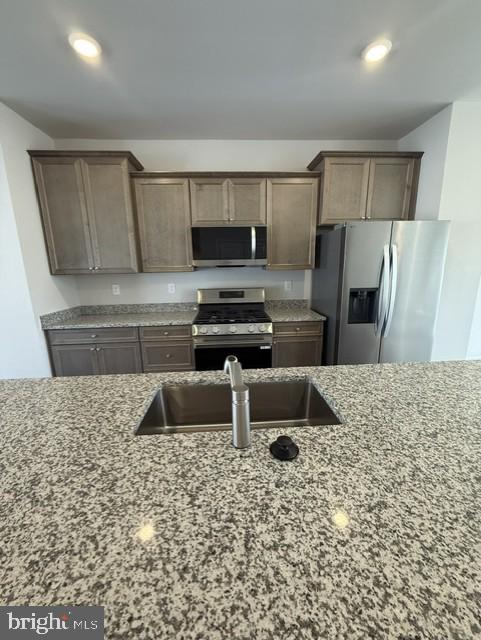7608 River Reach Road Baltimore, MD 21244 - Photo 5 of 14 a kitchen with a sink a stove a microwave and refrigerator