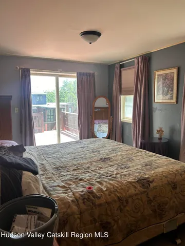 a bedroom with a bed and a large window