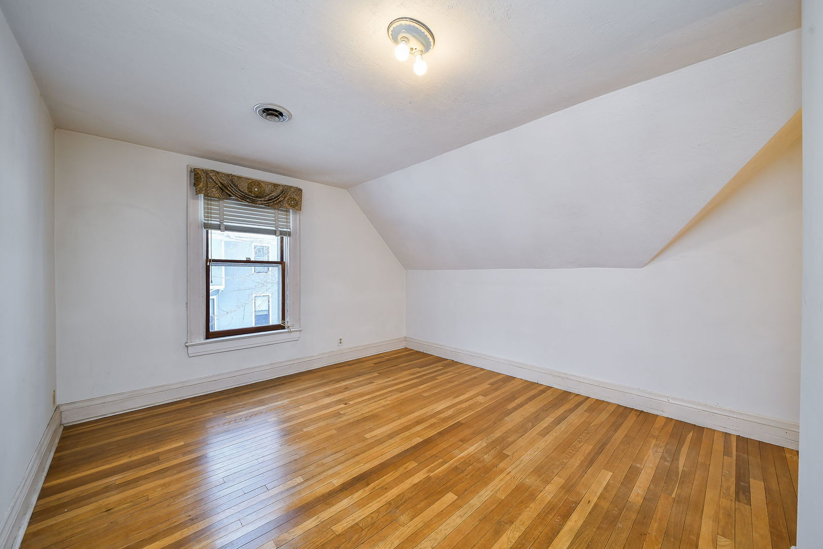 116 South Wright Street Naperville, IL 60540 - Photo 22 of 49 a view of an empty room with wooden floor and a window