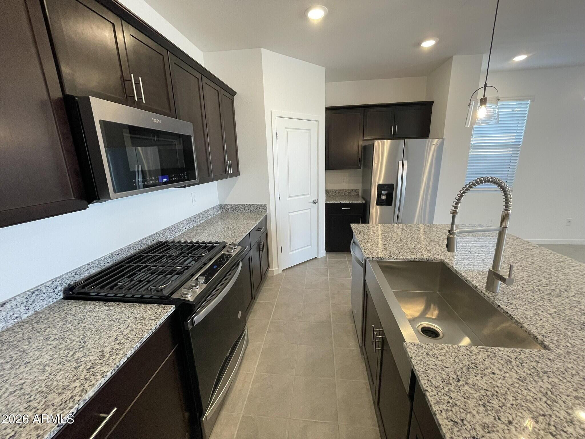 37014 West Prado Street Maricopa, AZ 85138 - Photo 11 of 18 a kitchen with stainless steel appliances granite countertop a sink stove and refrigerator