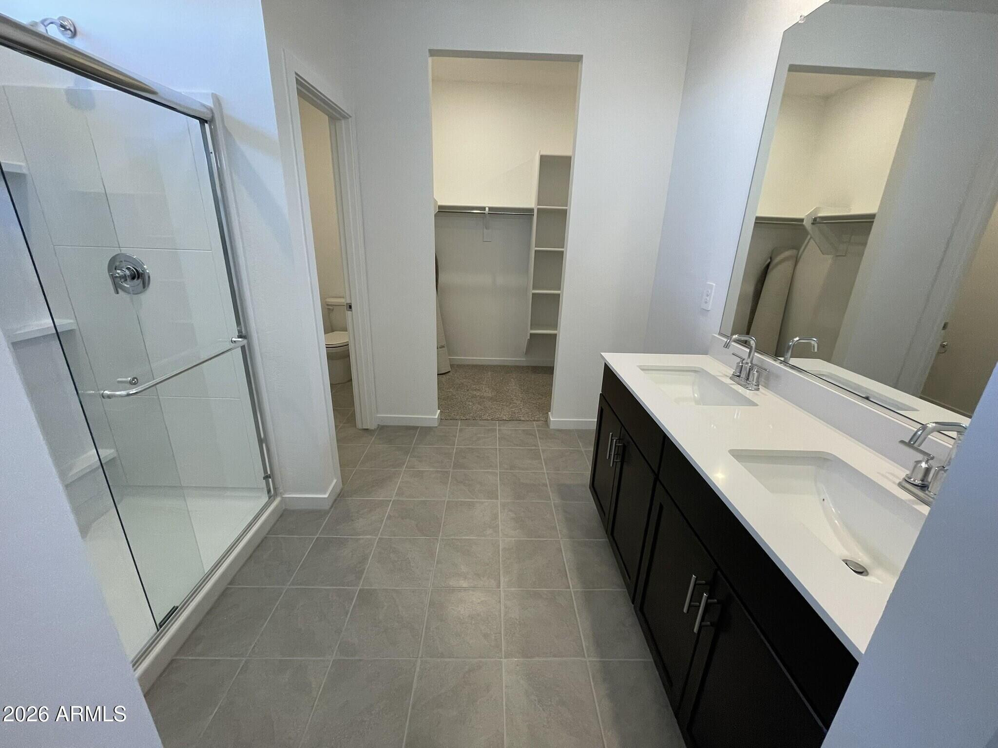 37014 West Prado Street Maricopa, AZ 85138 - Photo 13 of 18 a bathroom with a double vanity sink a mirror and a shower