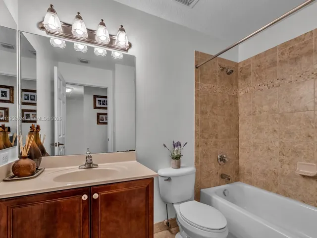 a bathroom with a sink a toilet a mirror a bathtub and shower